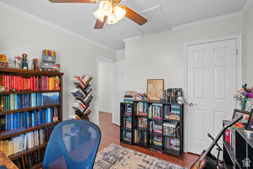Office space with a ceiling fan, wood finished floors, and crown molding