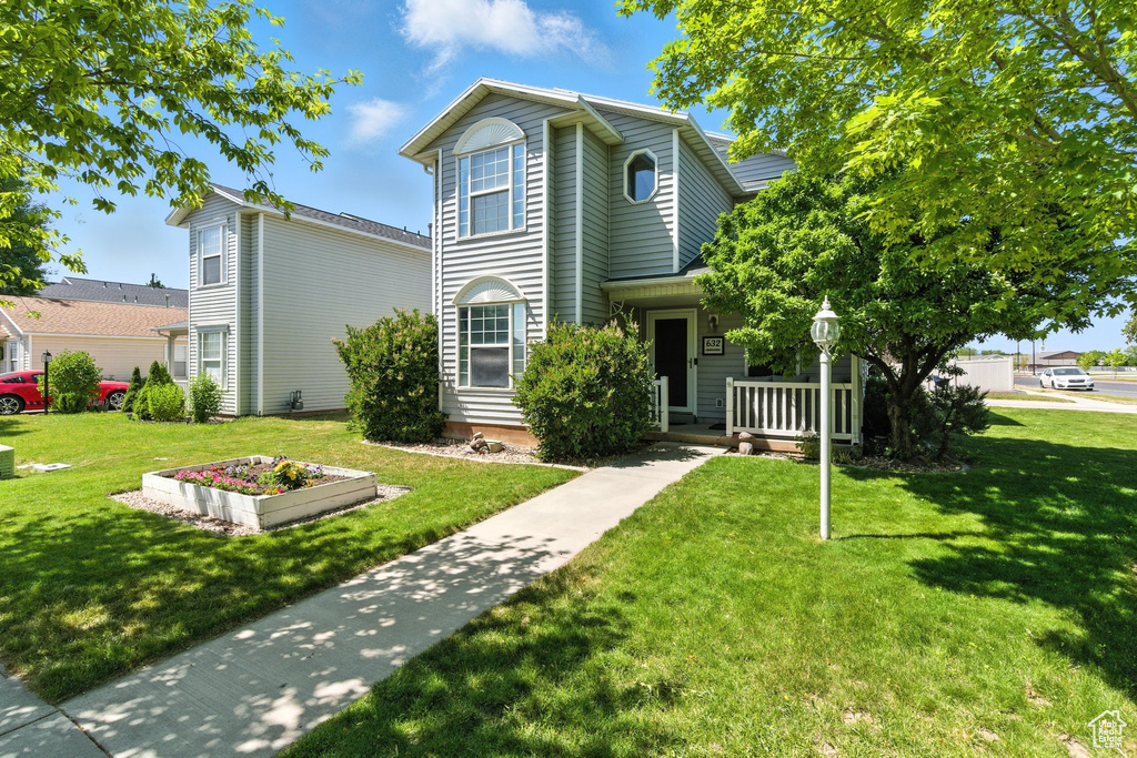 Traditional home with a front yard and a porch