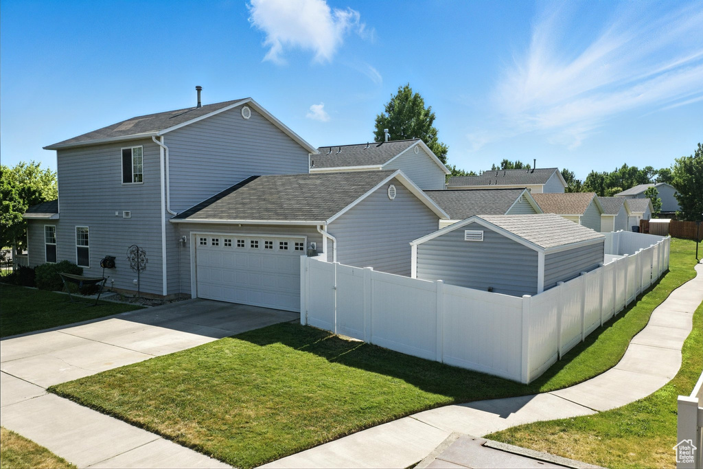 View of side of home featuring an attached garage, roof with shingles, and concrete driveway