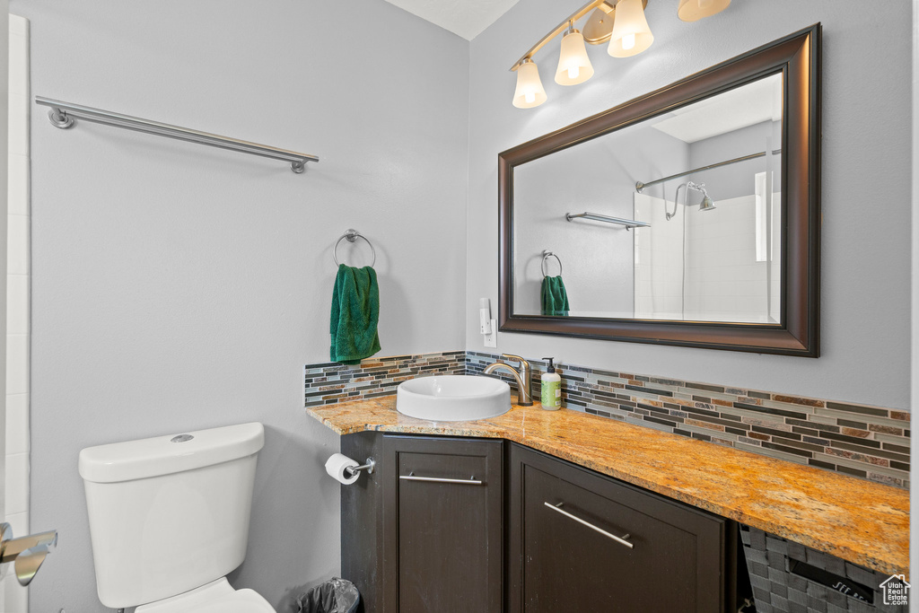 Full bathroom with tasteful backsplash, vanity, and a shower