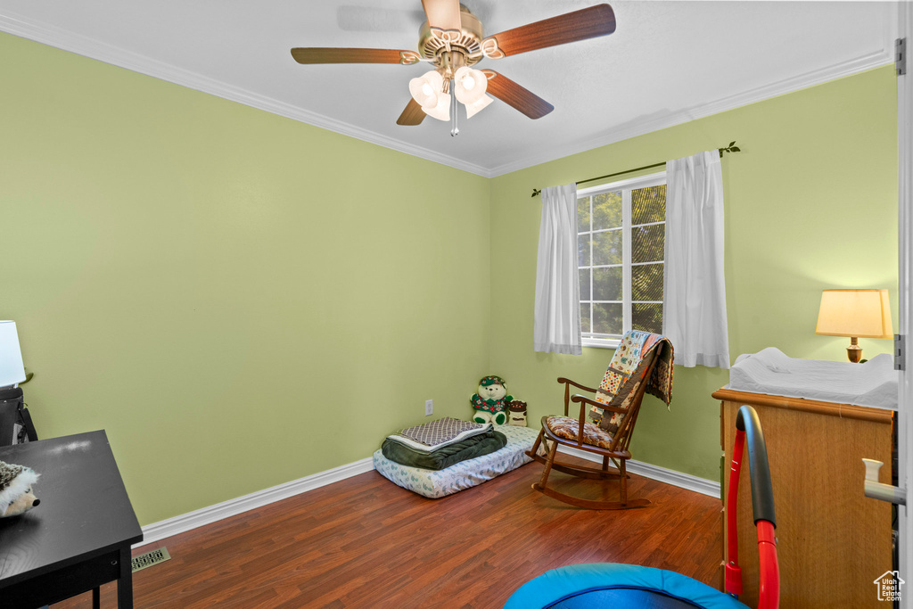 Living area featuring wood finished floors, ornamental molding, and a ceiling fan
