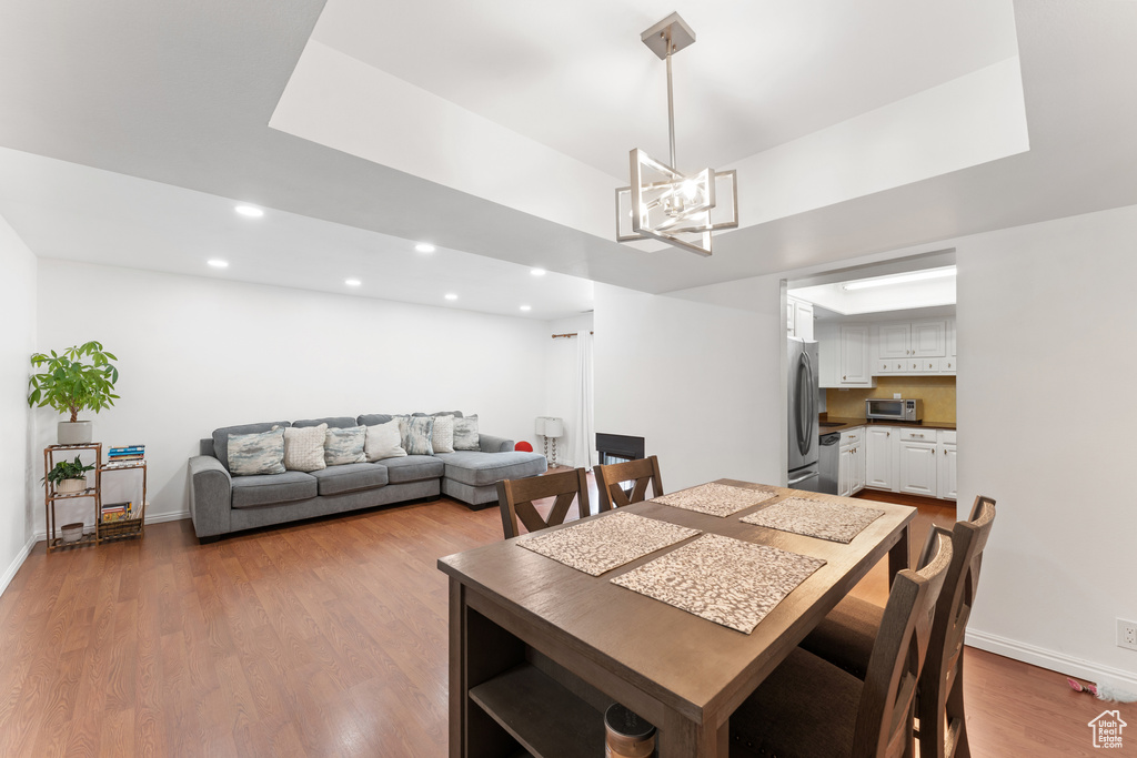 Dining room with recessed lighting, wood finished floors, and a chandelier