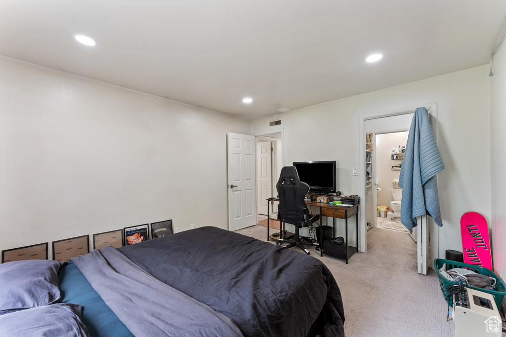 Bedroom with light carpet, recessed lighting, and ensuite bathroom