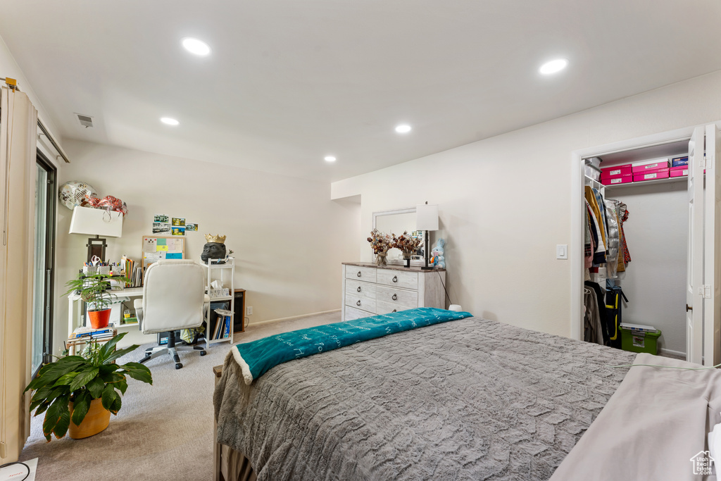 Carpeted bedroom with recessed lighting, an office area, and a walk in closet