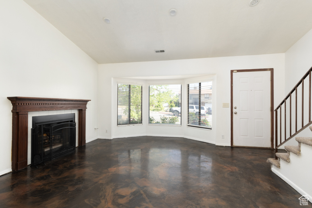 Unfurnished living room featuring stairs and a fireplace