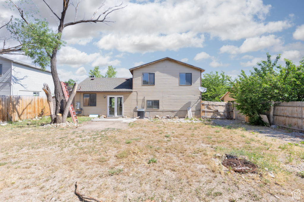 Rear view of house featuring french doors, an outdoor fire pit, and a fenced backyard