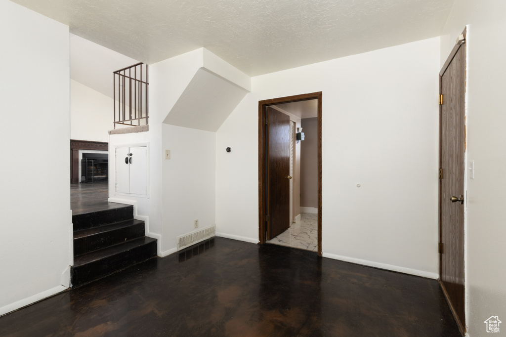 Unfurnished living room with stairway and baseboards