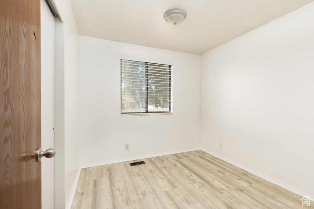 Spare room featuring light wood-type flooring and baseboards
