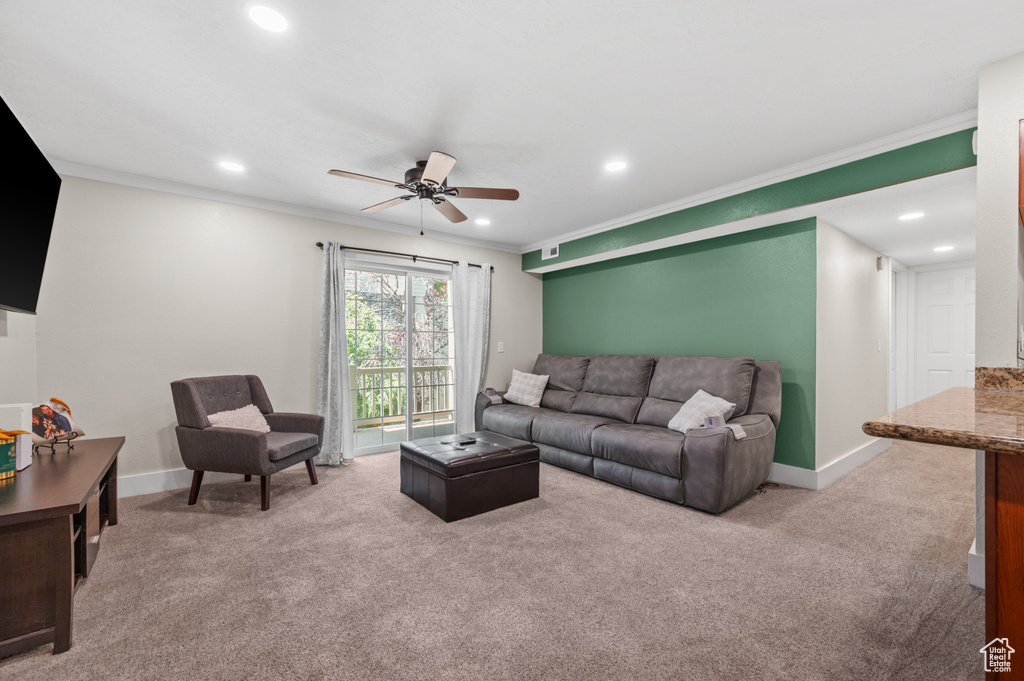 Carpeted living area with recessed lighting, a ceiling fan, and crown molding