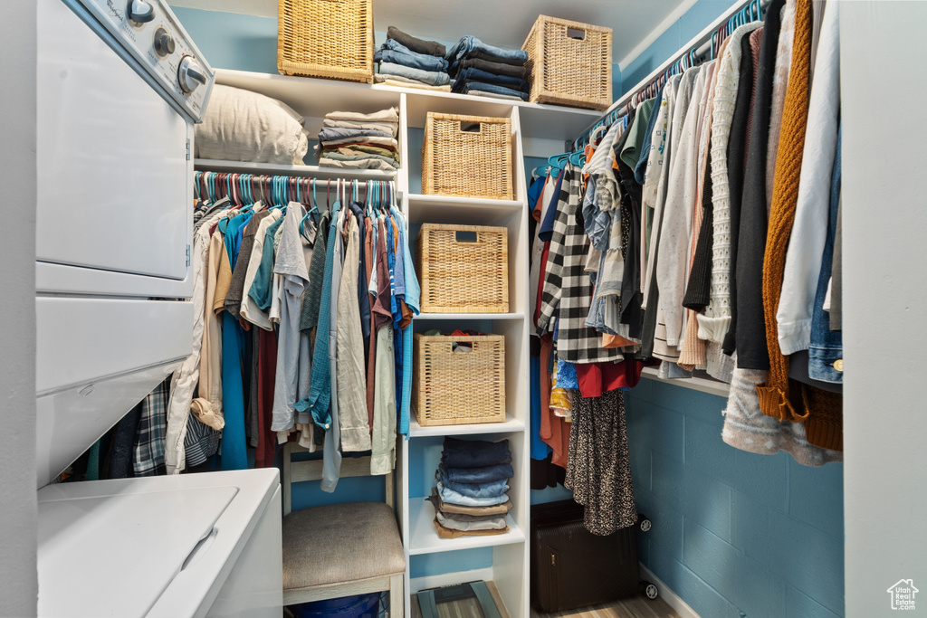 Walk in closet featuring stacked washing machine and dryer