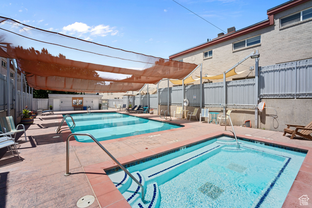 Community pool featuring a fenced backyard, a hot tub, a patio area, and a pergola