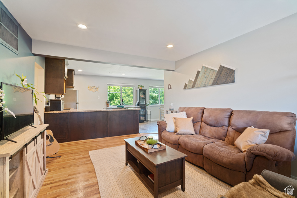 Living room with light wood finished floors and recessed lighting