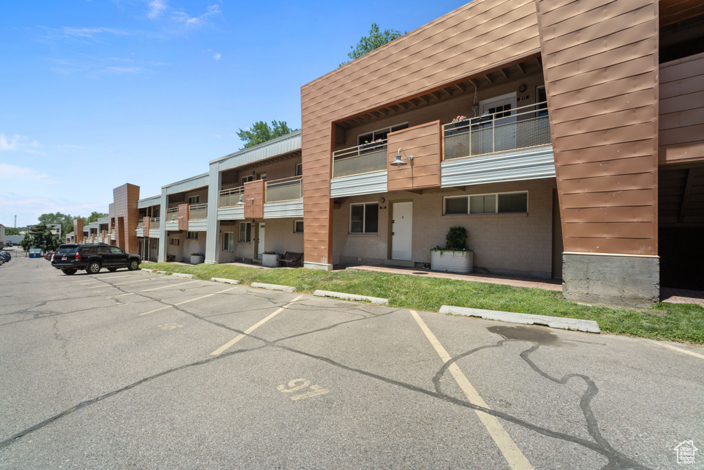 View of building exterior featuring uncovered parking