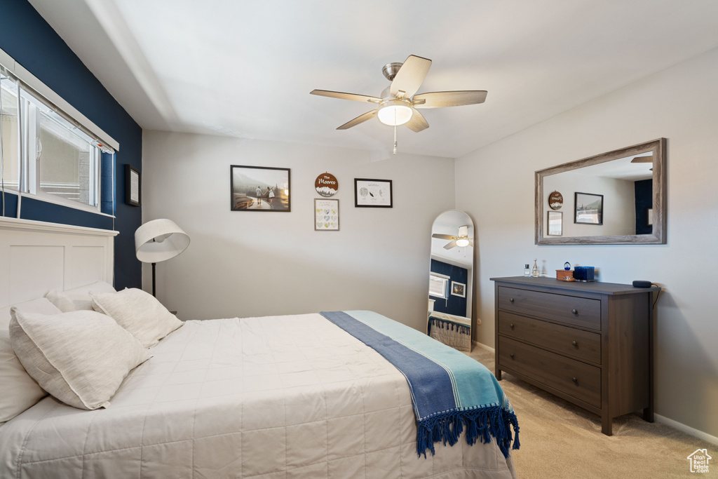 Bedroom with light carpet and a ceiling fan
