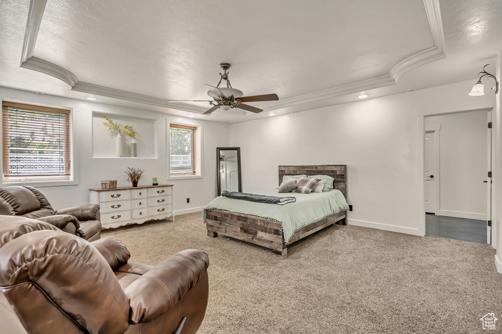 Carpeted bedroom featuring crown molding, a raised ceiling, ceiling fan, and recessed lighting