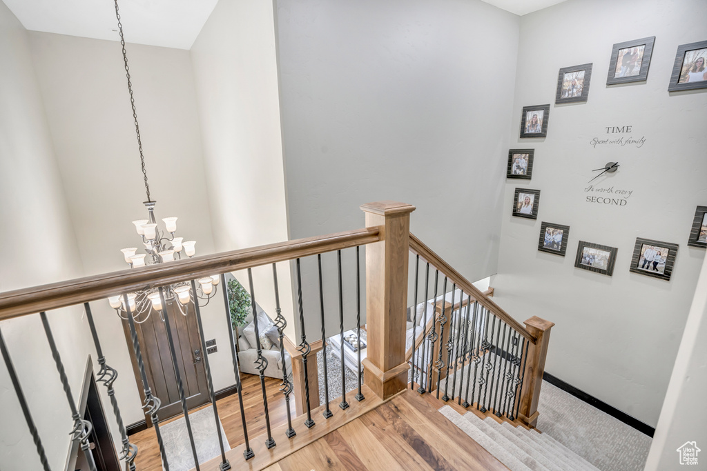 Stairs featuring a chandelier and wood finished floors