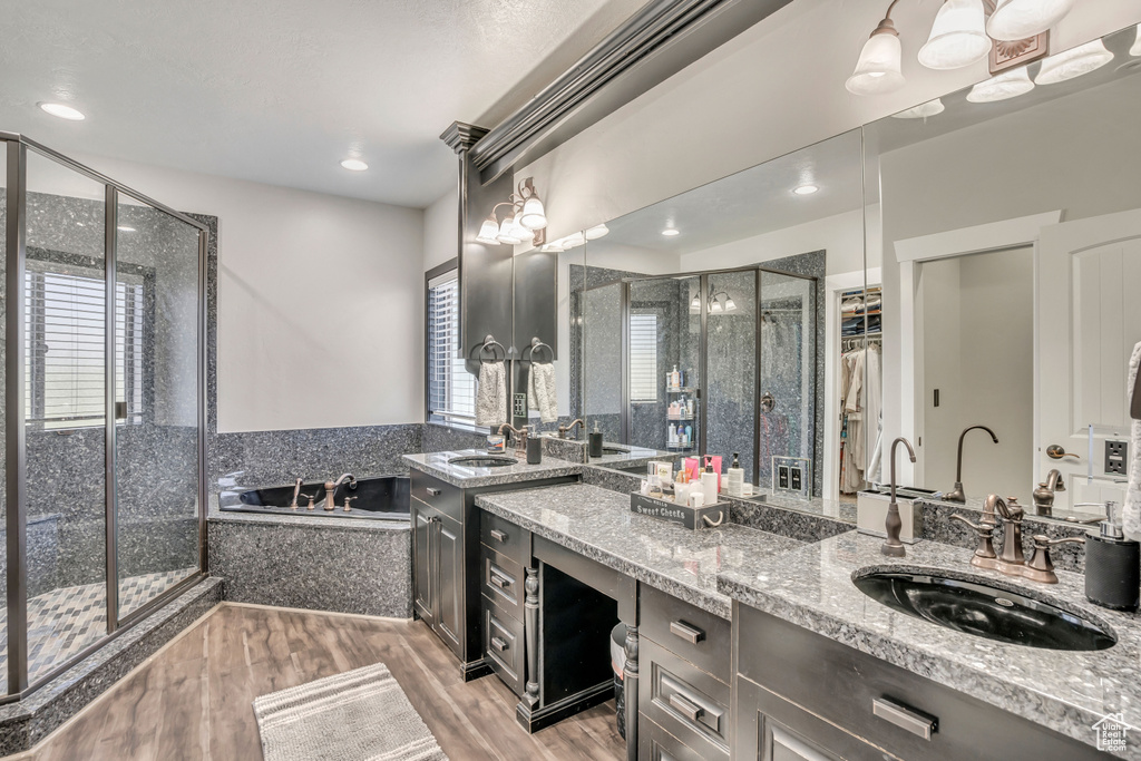 Bathroom with a stall shower, a bath, vanity, wood finished floors, and a closet