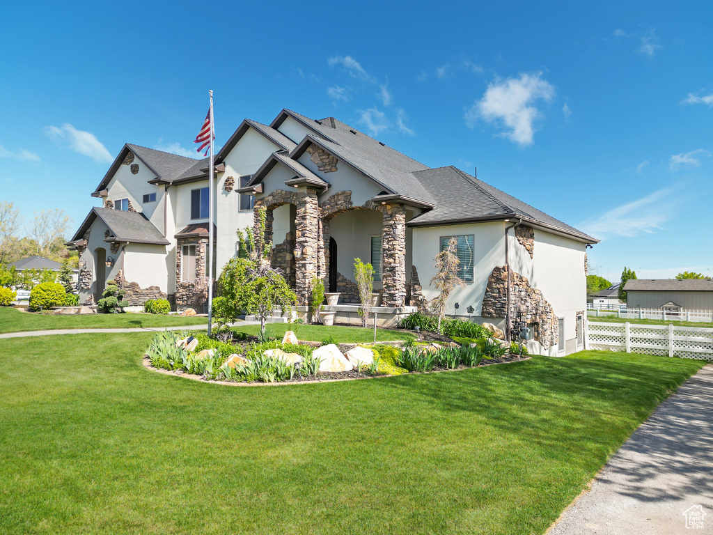 French country inspired facade featuring stucco siding and stone siding