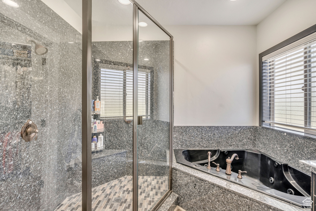 Bathroom with a stall shower and a jetted tub