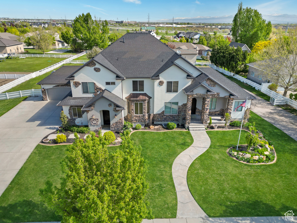 View of front of home featuring stone siding, stucco siding, a shingled roof, concrete driveway, and a residential view