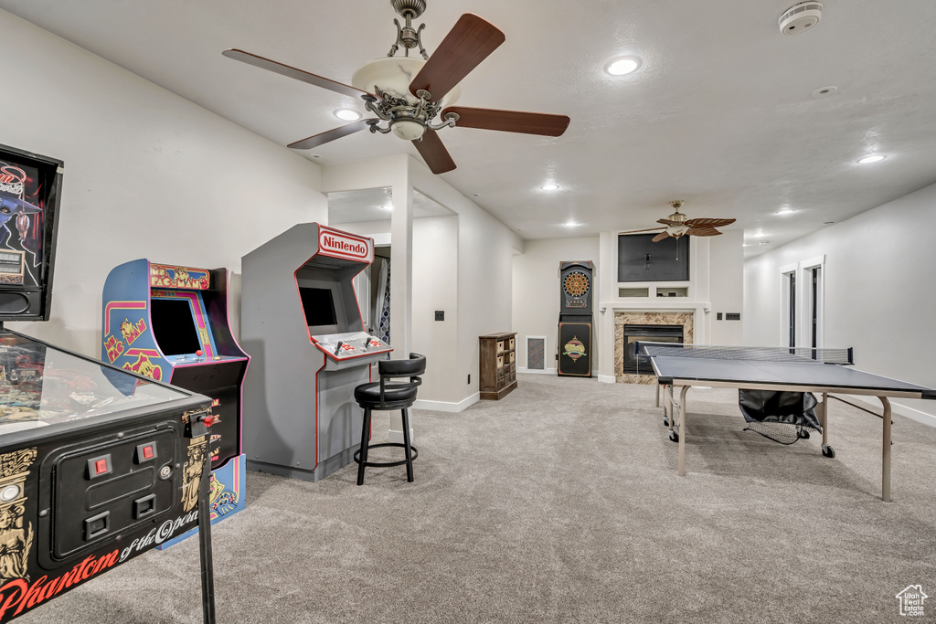 Game room with a ceiling fan, carpet, a tiled fireplace, and recessed lighting
