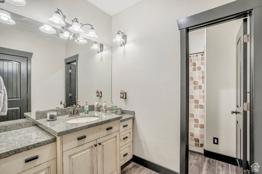 Bathroom featuring wood finished floors, vanity, and a shower with curtain