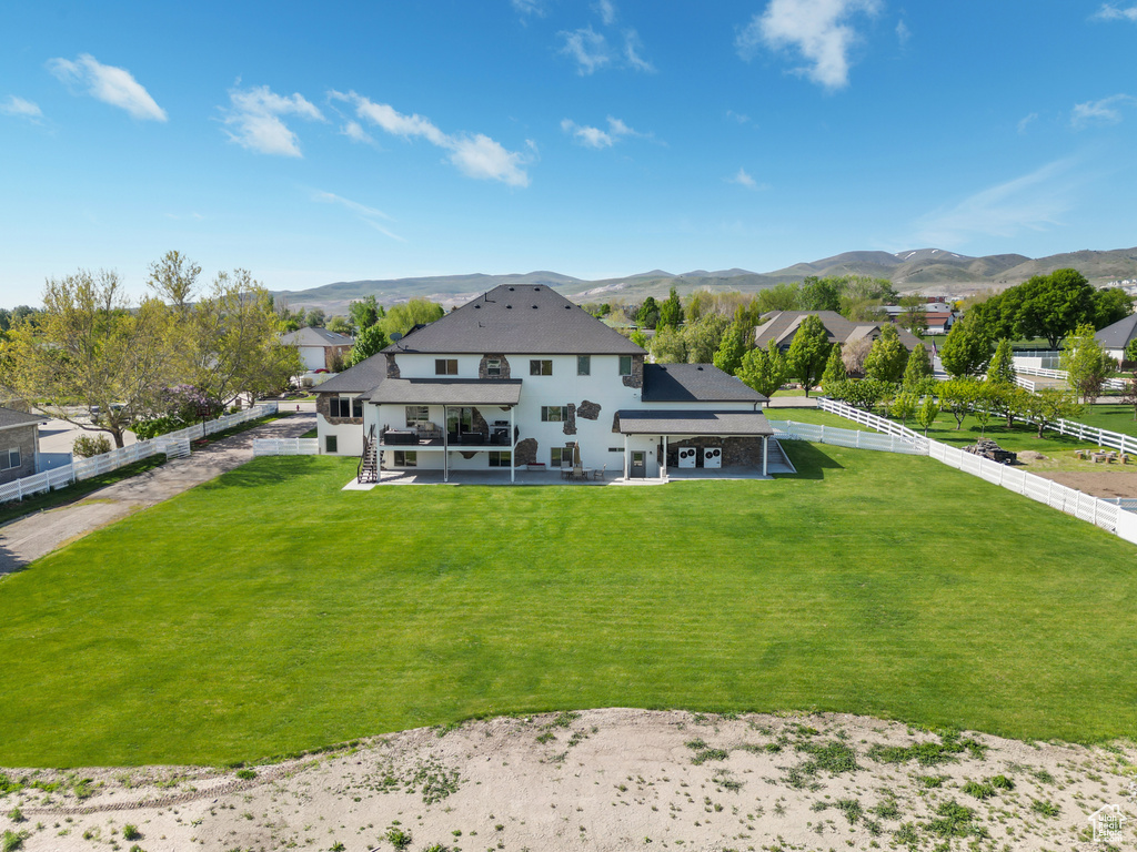 Back of house featuring a patio, a mountain view, and a fenced backyard