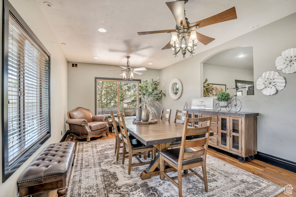 Dining room with a ceiling fan, wood finished floors, recessed lighting, and arched walkways