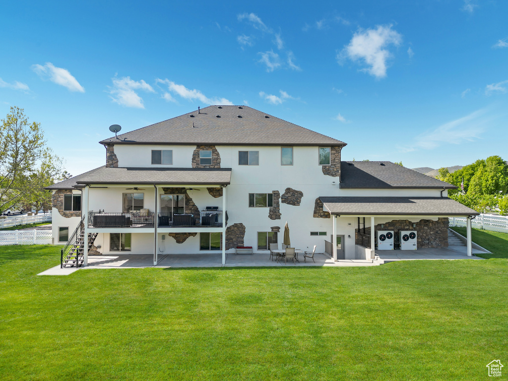 Rear view of house featuring a patio, ceiling fan, stairs, stucco siding, and roof with shingles