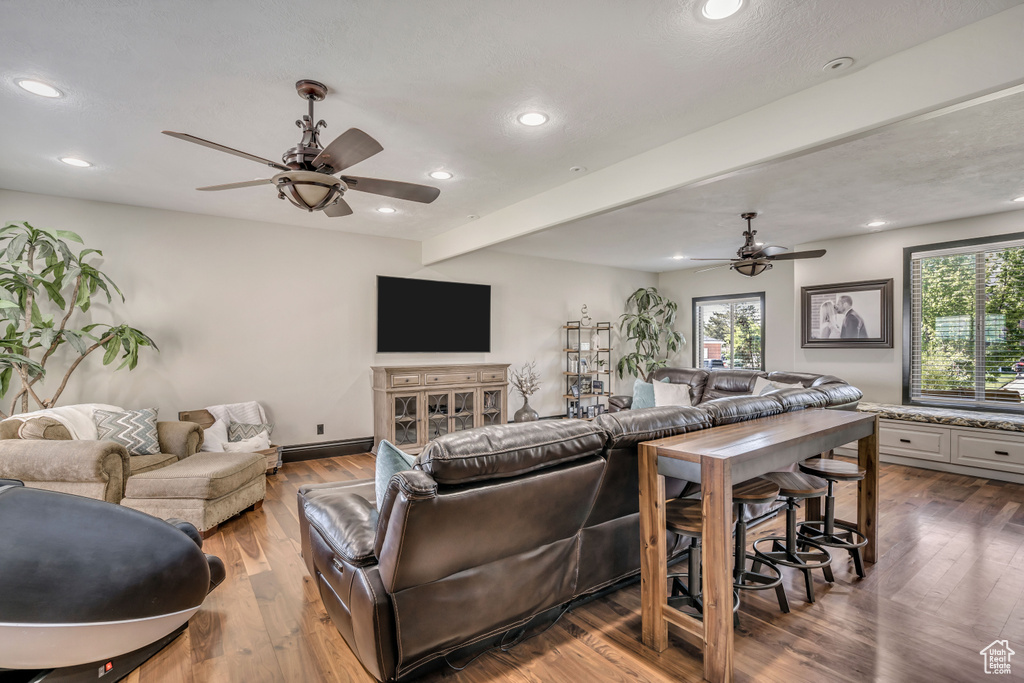 Living room featuring ceiling fan, beam ceiling, recessed lighting, and dark wood finished floors