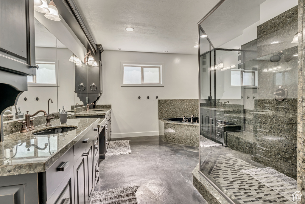 Bathroom with a bath, a stall shower, vanity, and concrete flooring