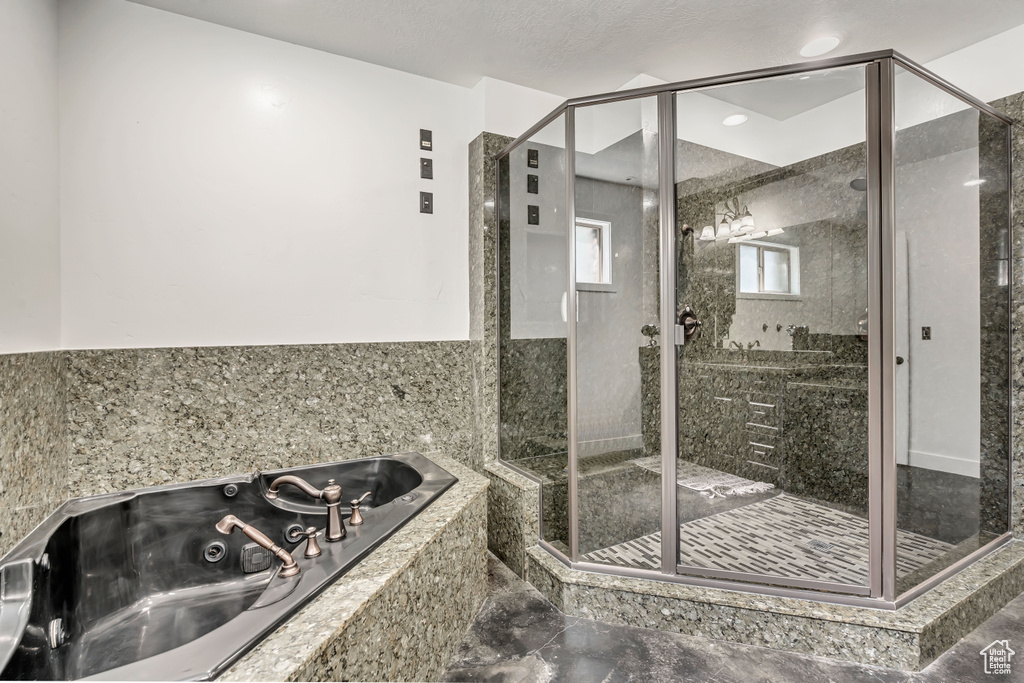 Full bathroom featuring a whirlpool tub, a stall shower, and marble finish floors