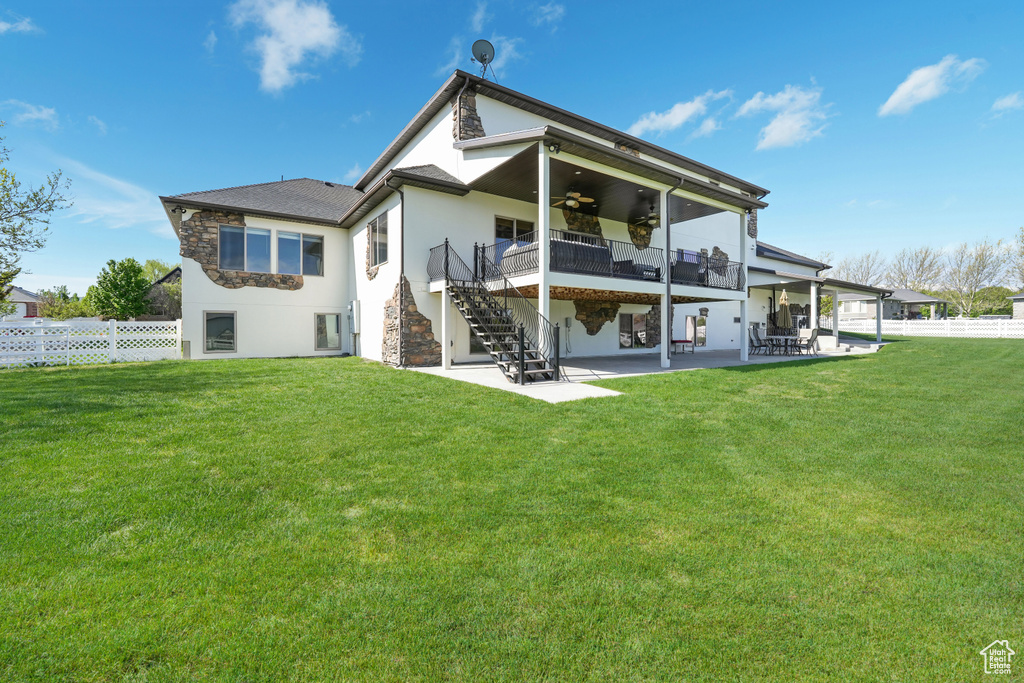 Rear view of property with a ceiling fan, stairs, a patio, stucco siding, and stone siding