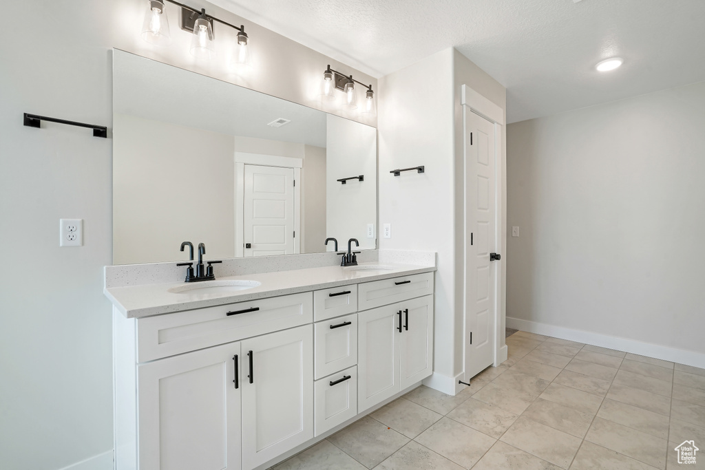 Full bath featuring double vanity and tile patterned flooring