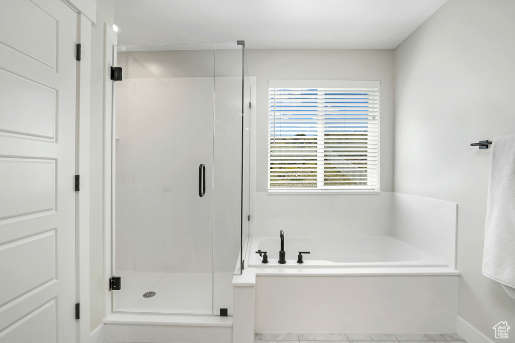 Full bath featuring a bath, a shower stall, and tile patterned floors