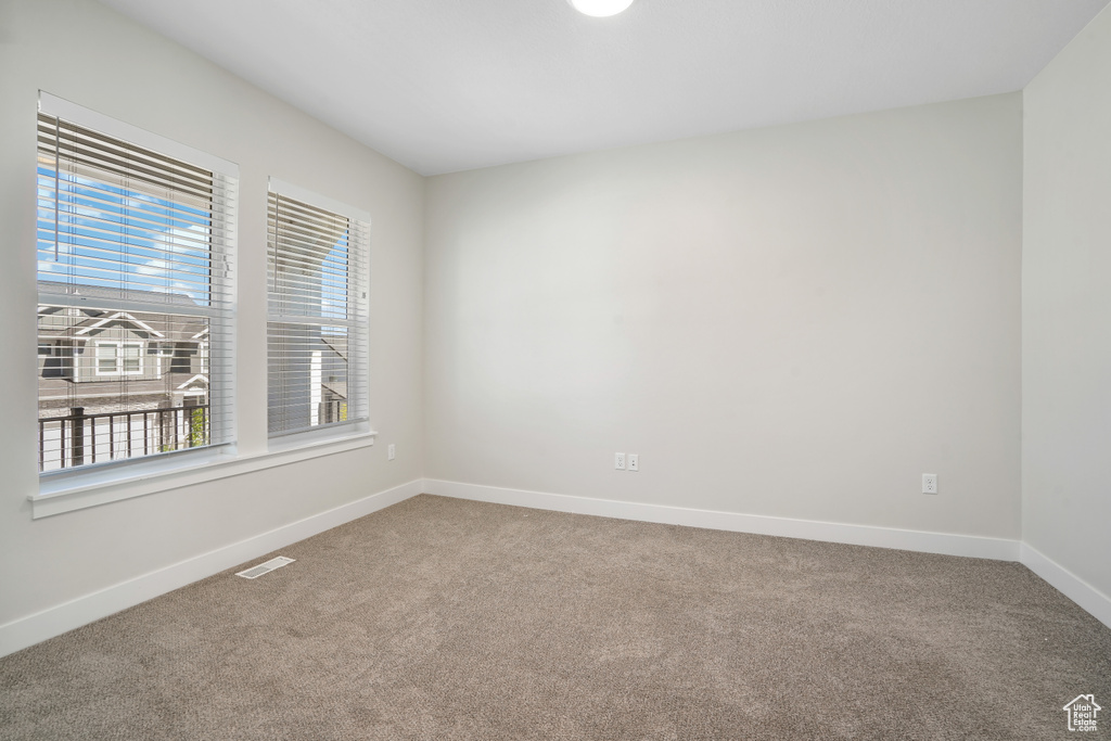 Empty room featuring carpet and baseboards