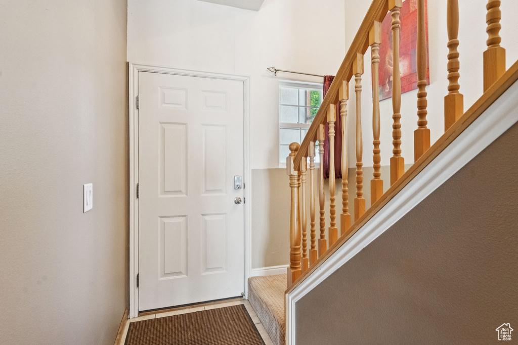 Foyer entrance featuring stairway and baseboards