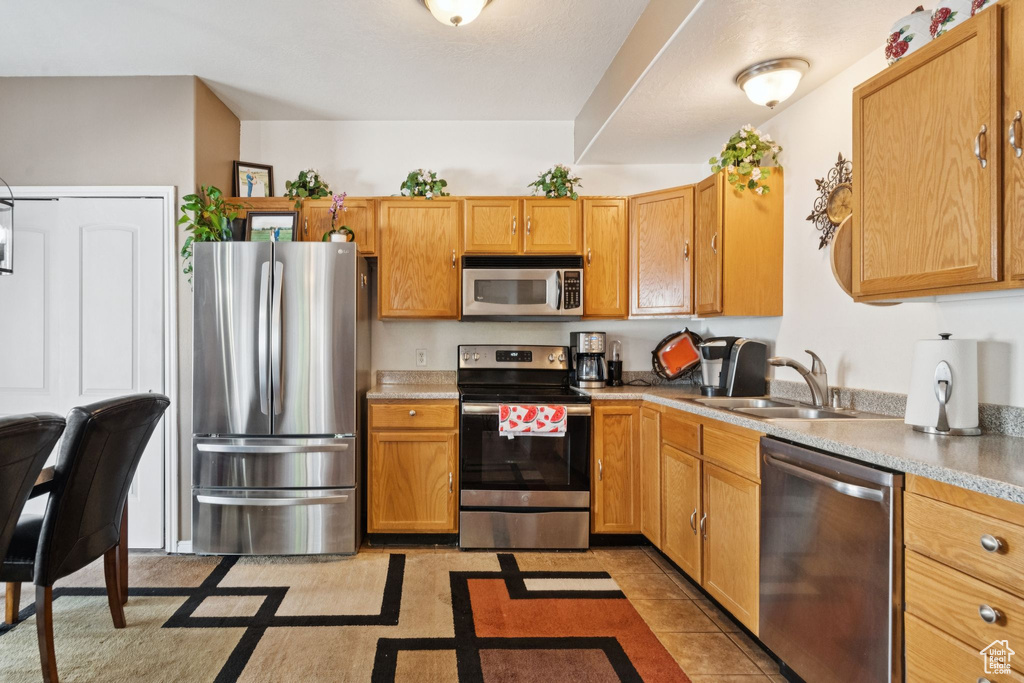 Kitchen with appliances with stainless steel finishes and light countertops