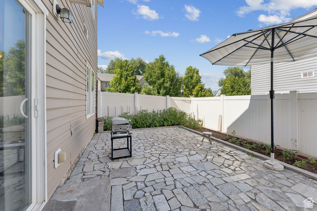 Fenced backyard featuring a patio area and grilling area