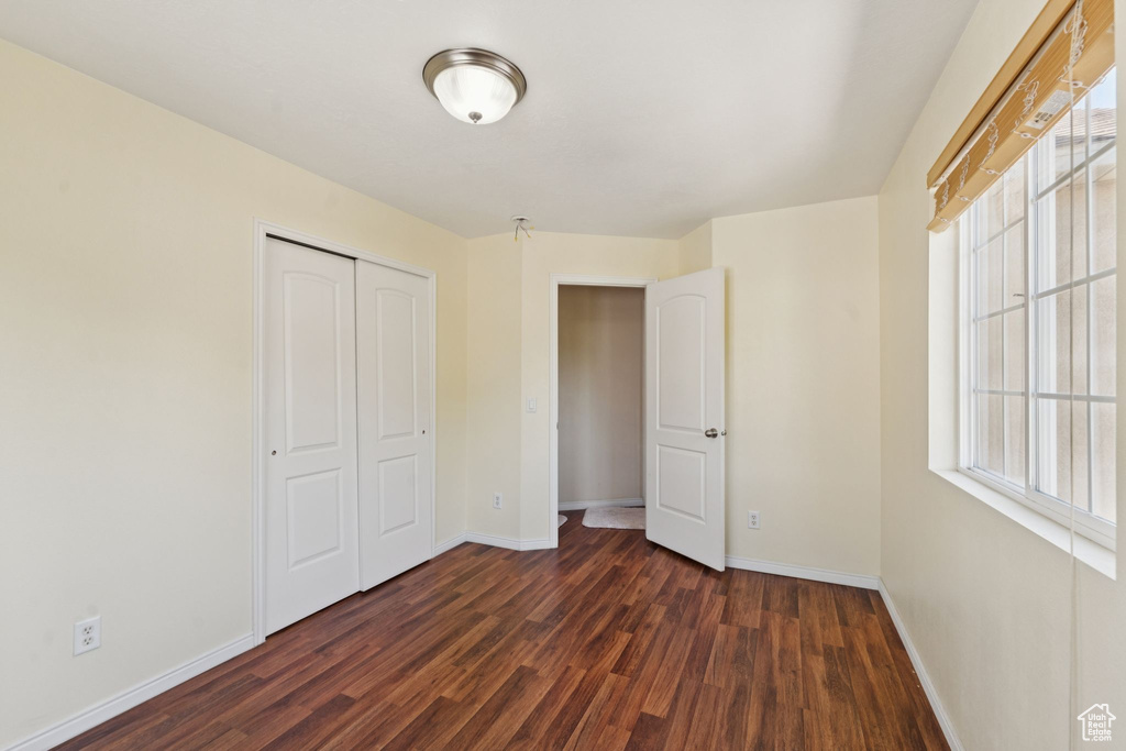 Unfurnished bedroom with dark wood finished floors and a closet