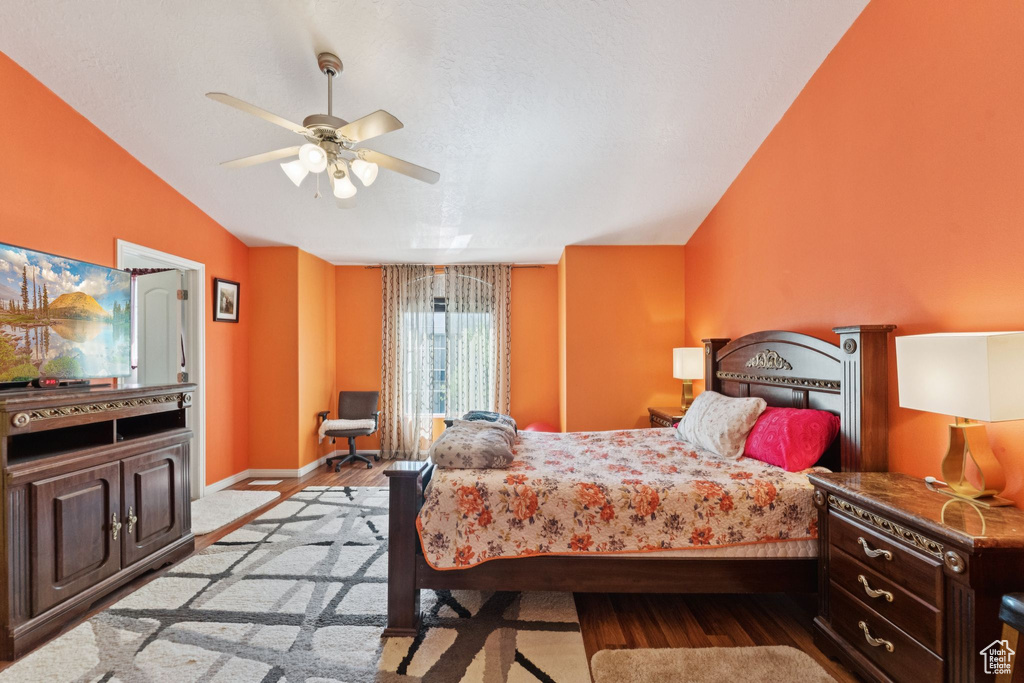 Bedroom featuring wood finished floors, vaulted ceiling, and a ceiling fan