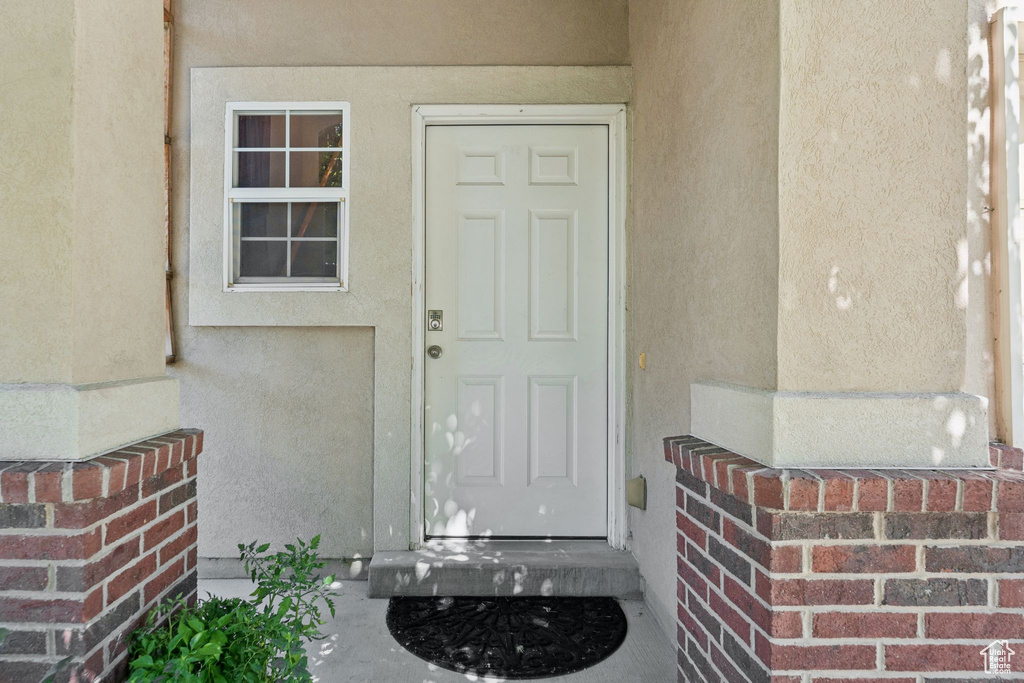Doorway to property featuring stucco siding