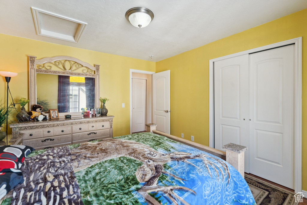 Bedroom featuring attic access and a closet