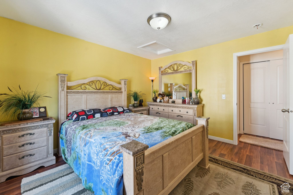 Bedroom with attic access and wood finished floors