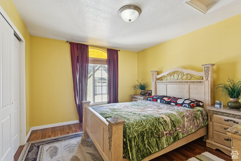 Bedroom with wood finished floors, a closet, and a textured ceiling
