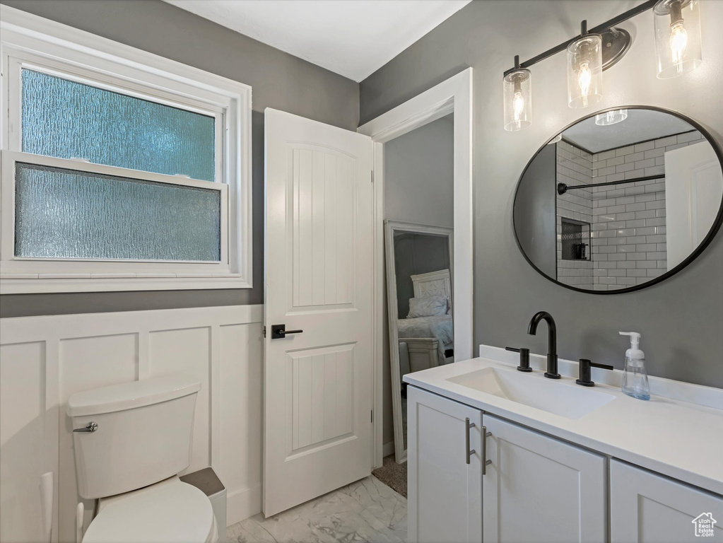Full bath with vanity, marble finish floors, and tiled shower