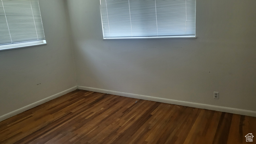 Spare room with baseboards and wood finished floors