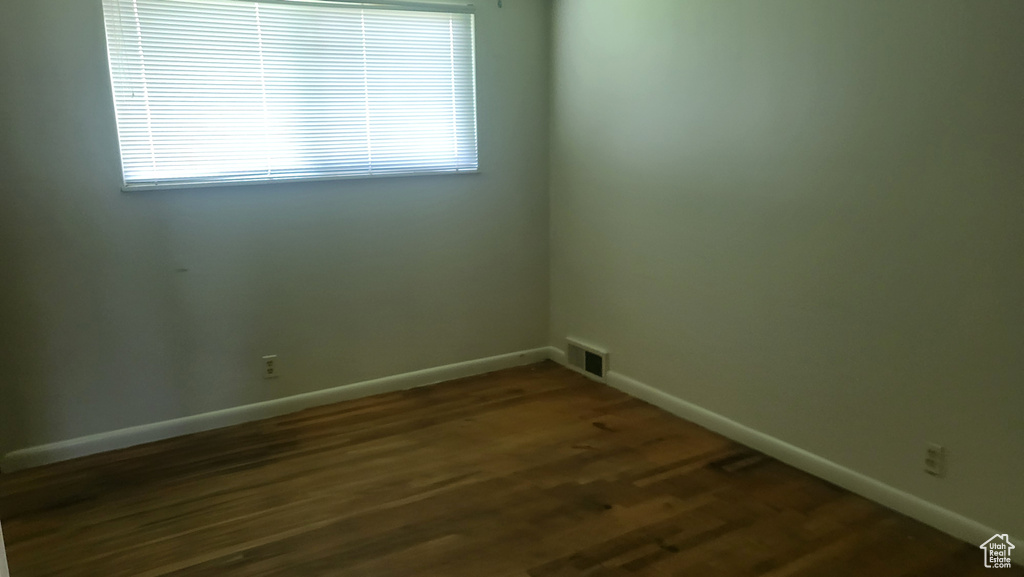 Spare room with baseboards and dark wood finished floors