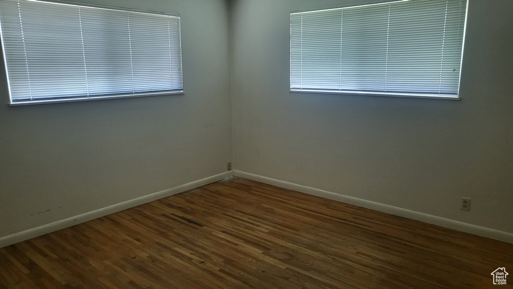 Spare room featuring baseboards and wood finished floors