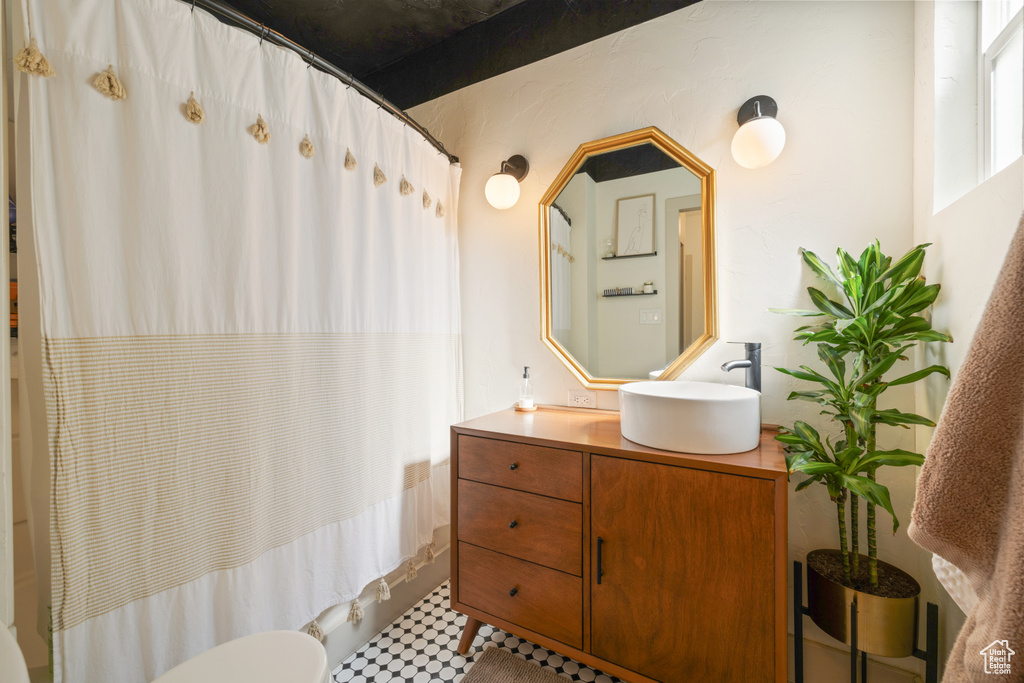 Bathroom with vanity, shower / bath combination with curtain, and tile patterned floors